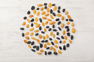 Flat lay composition with raisins on white wooden background. Dried fruit as healthy snack