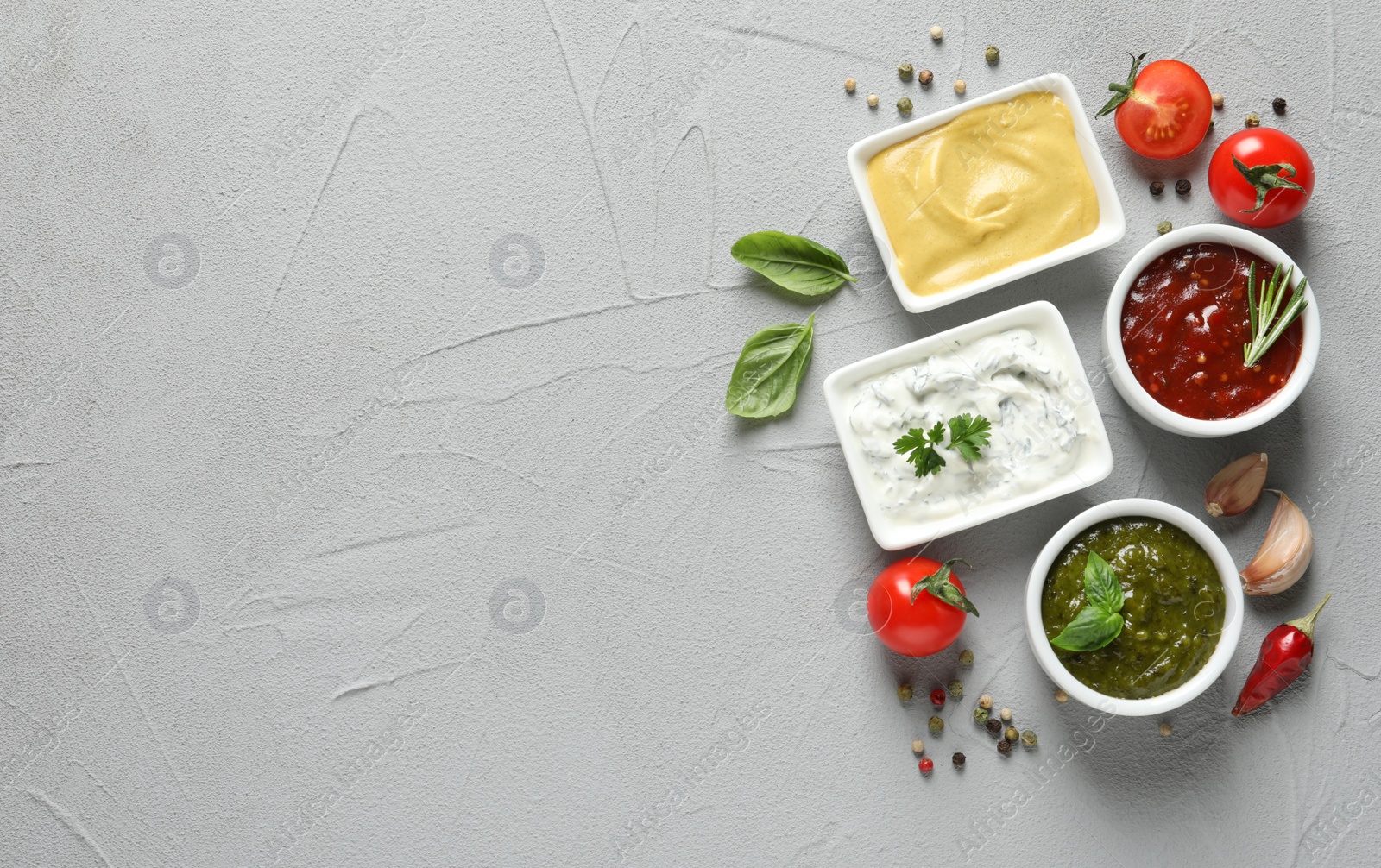 Photo of Flat lay composition with different sauces and space for text on gray background