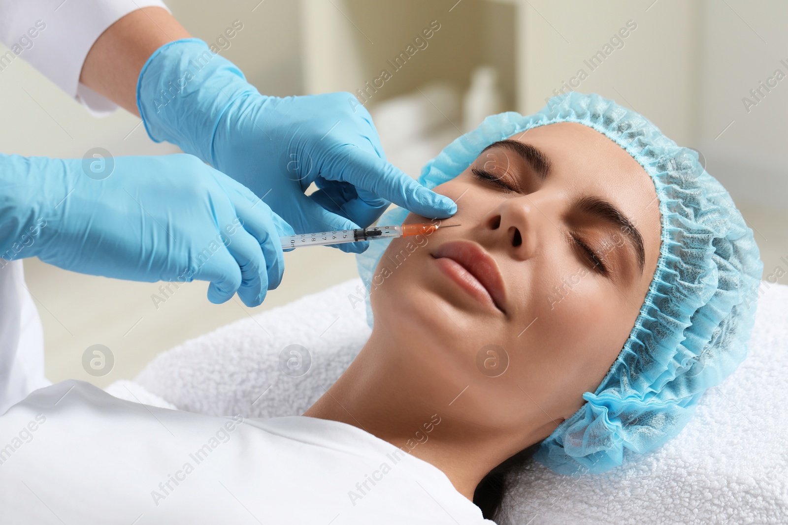 Photo of Doctor giving facial injection to young woman in clinic. Cosmetic surgery