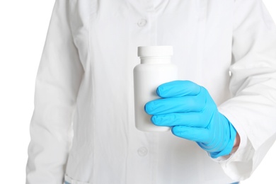 Photo of Doctor in medical glove holding bottle of pills on white background