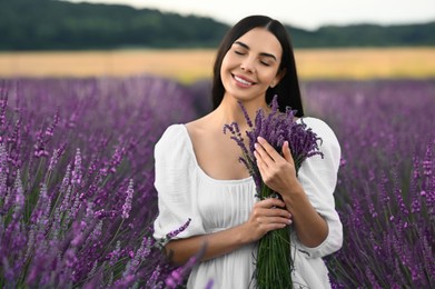 Beautiful young woman with bouquet in lavender field