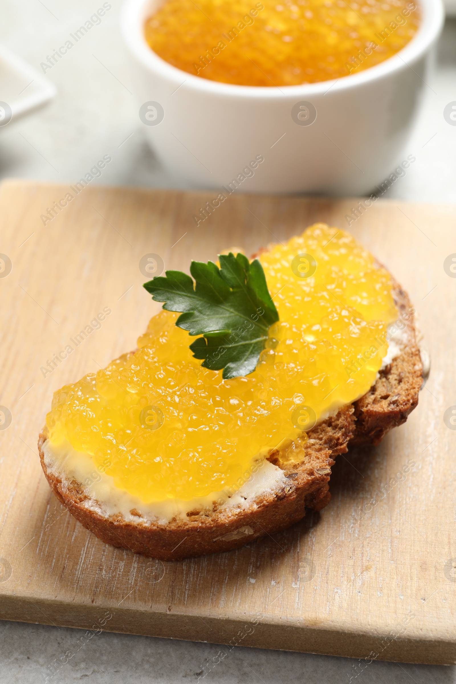 Photo of Tasty sandwich with pike caviar and parsley on table, closeup