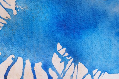 Photo of Abstract blue watercolor painting on white paper, top view