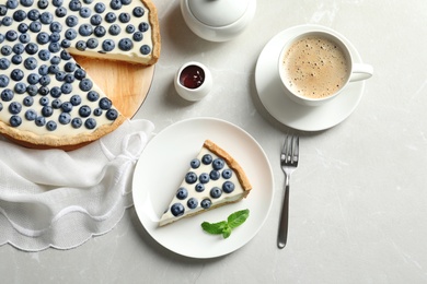 Flat lay composition with piece of tasty blueberry cake on gray table