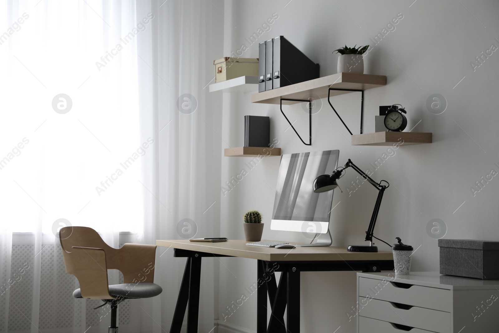 Photo of Comfortable office chair near table with modern computer