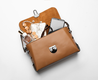 Stylish woman's bag with smartphone and accessories on white background, top view