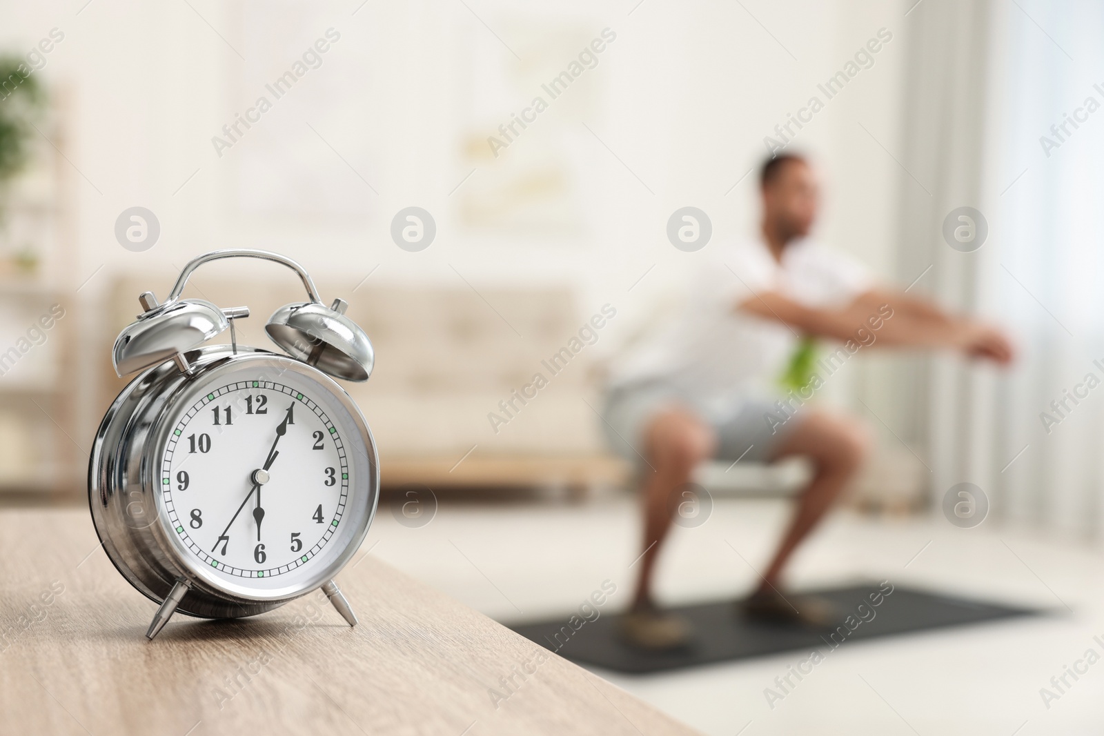 Photo of Man doing morning exercise on fitness mat at home, selective focus. Space for text