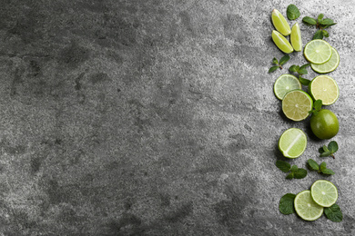 Photo of Lemonade layout with juicy lime slices and mint on grey table, top view. Space for text