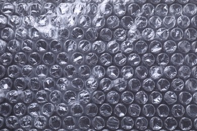 Photo of Transparent bubble wrap on black background, top view