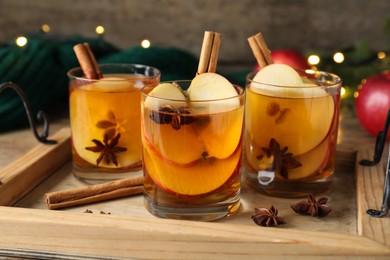 Photo of Hot mulled cider, cinnamon and anise on wooden tray