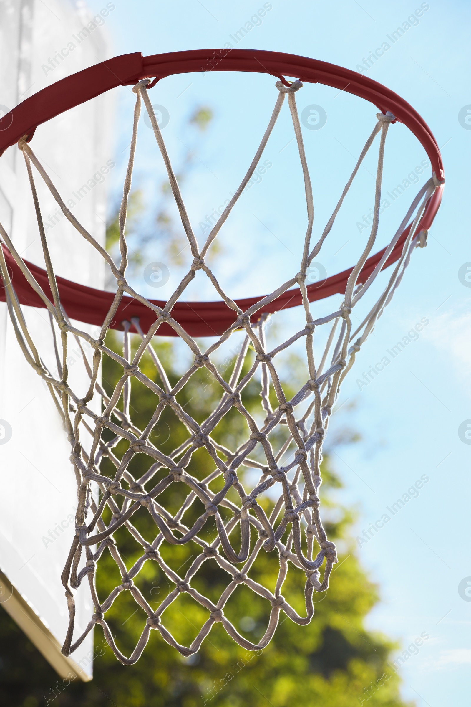 Photo of Basketball hoop with net outdoors on sunny day