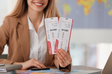 Photo of Travel agent with tickets at table in office, closeup