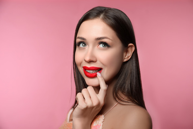 Photo of Beautiful woman with red lipstick on pink background