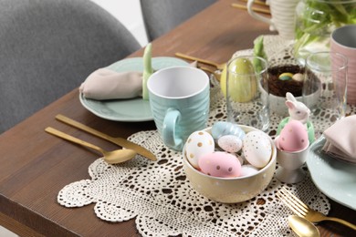 Photo of Festive table setting with painted eggs. Easter celebration