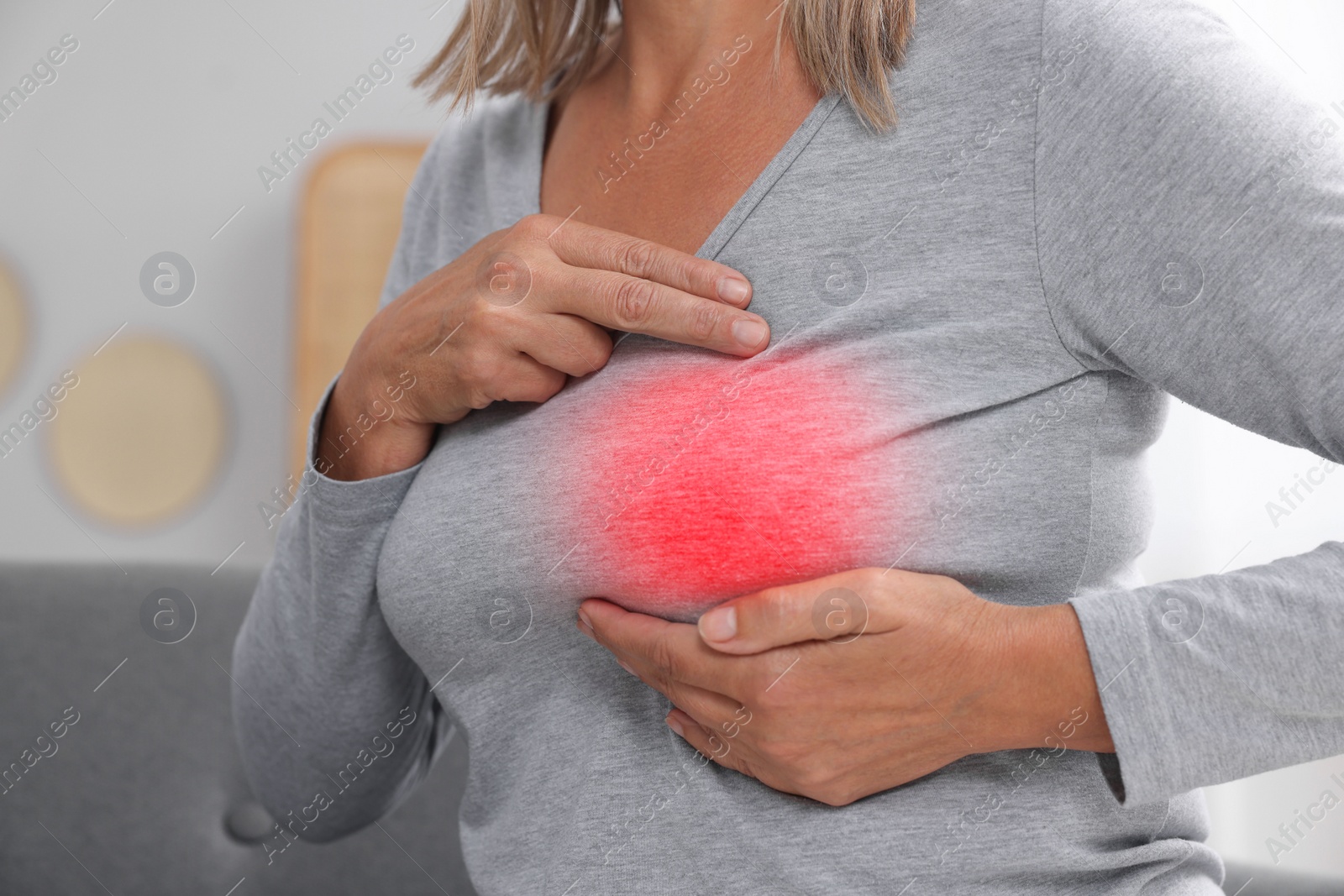 Image of Woman doing breast self-examination at home, closeup