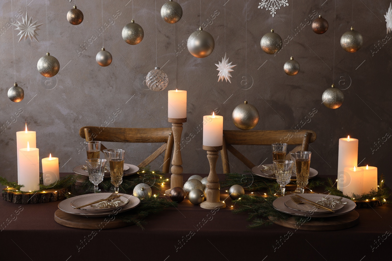 Photo of Christmas table setting with burning candles and festive decor