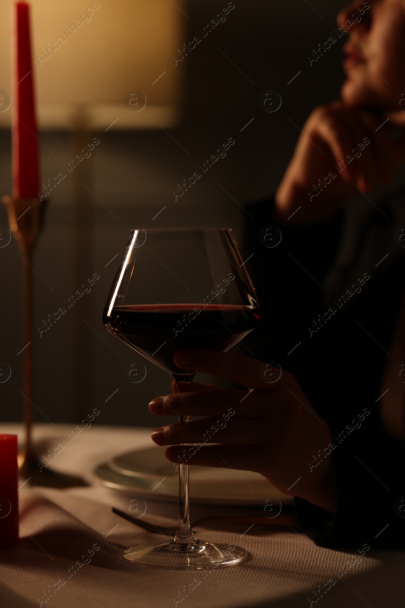 Photo of Beautiful young woman with glass of wine at table in restaurant, closeup