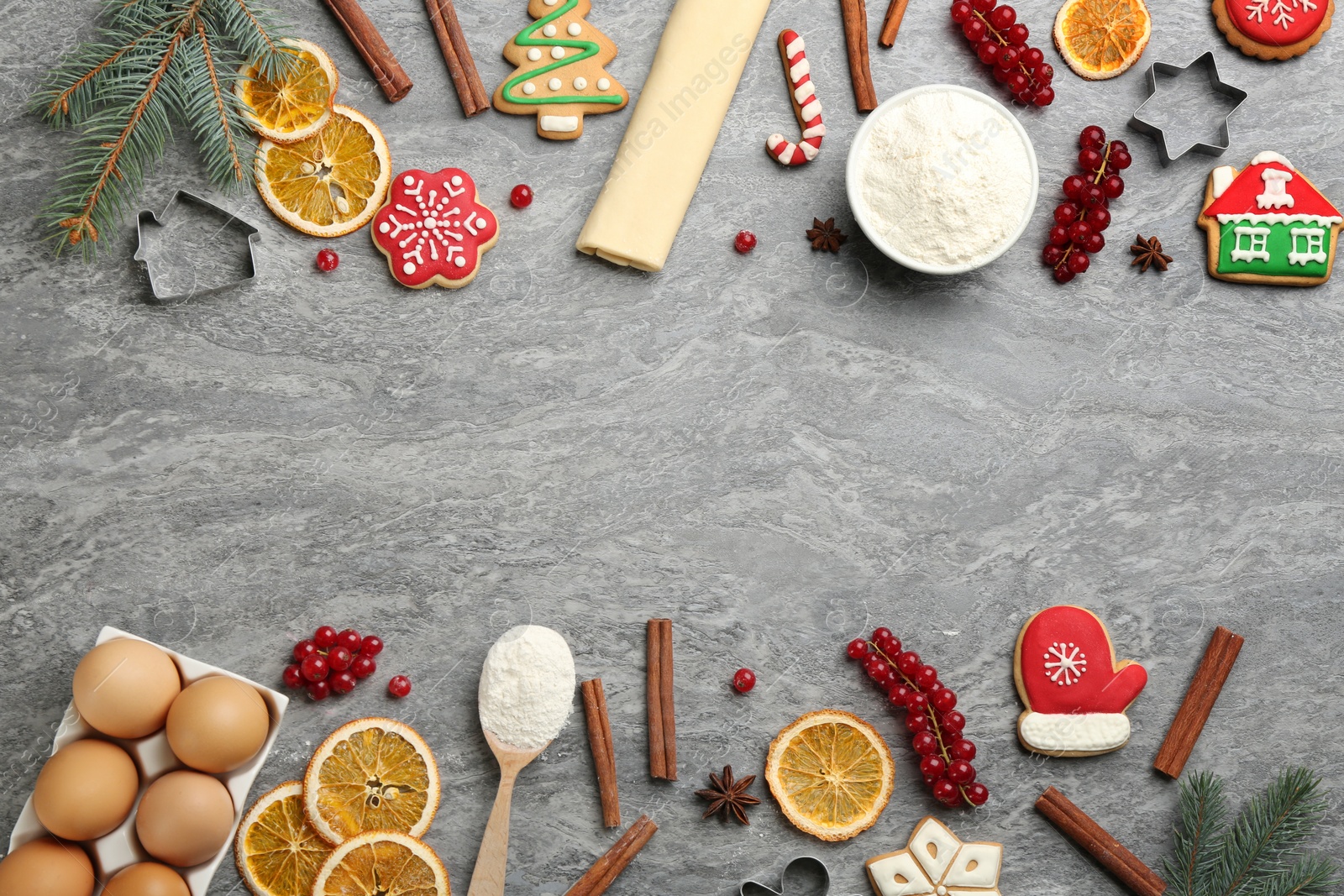 Photo of Frame of Christmas cookies and flour on grey table, flat lay. Space for text