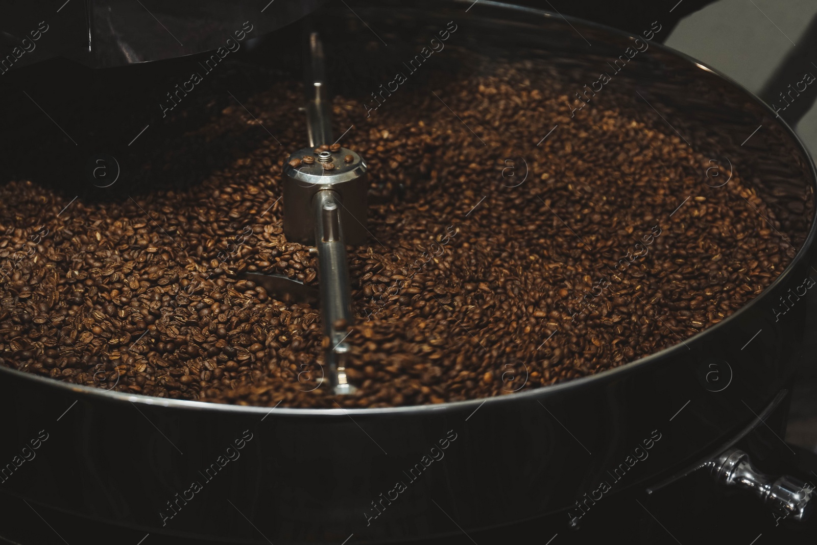 Photo of Modern coffee roaster machine with beans indoors, closeup