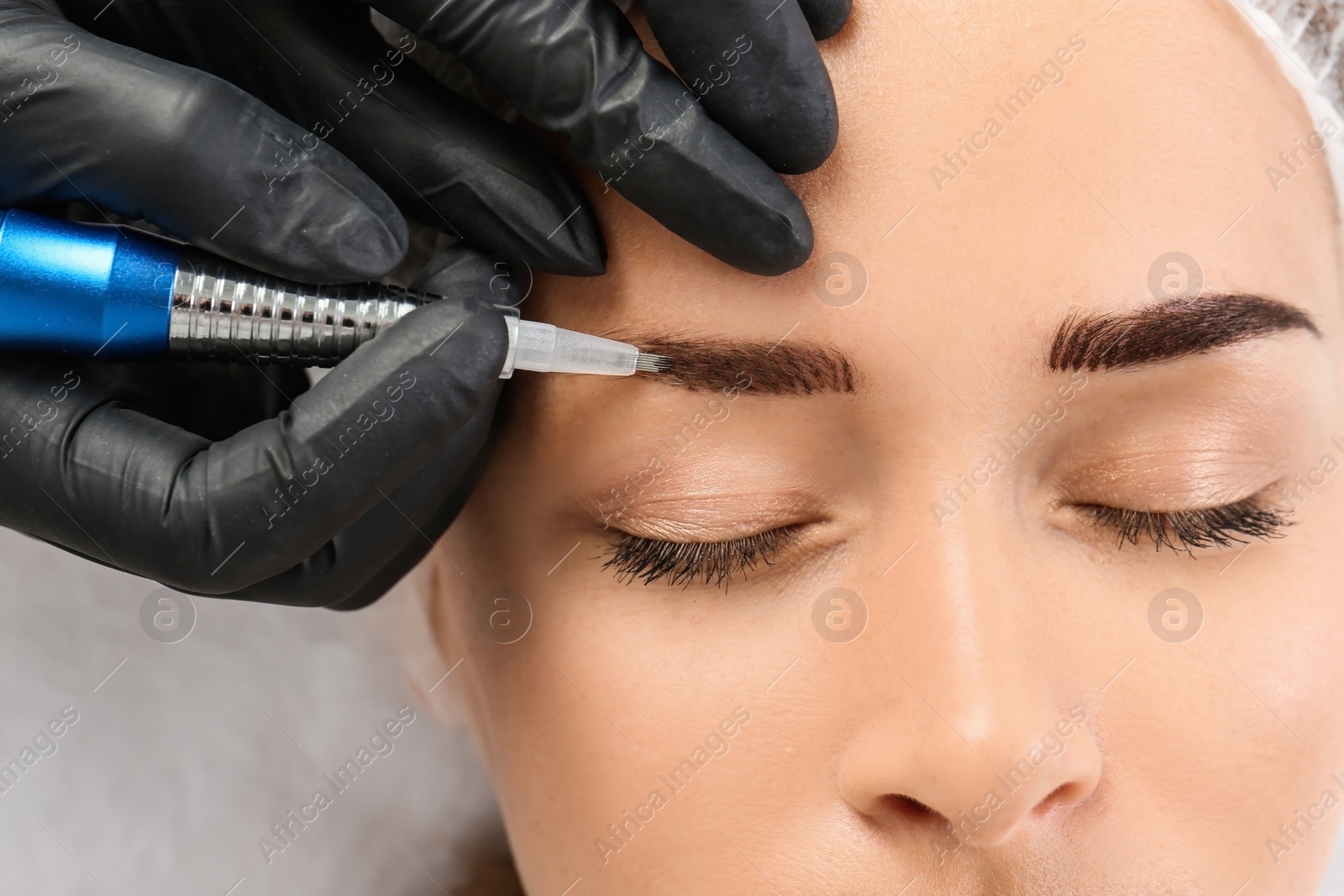 Photo of Young woman undergoing eyebrow correction procedure in salon, top view