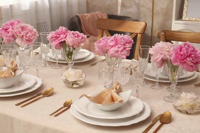 Photo of Stylish table setting with beautiful peonies and fabric napkins indoors
