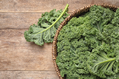 Photo of Fresh kale leaves on wooden table, top view