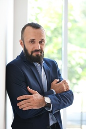 Photo of Portrait of handsome mature man in elegant suit near window