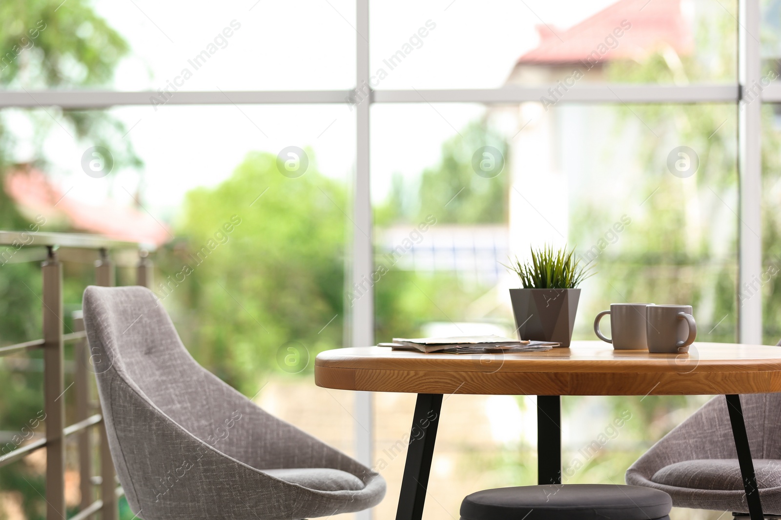 Photo of Stylish room interior with round table and comfortable chairs