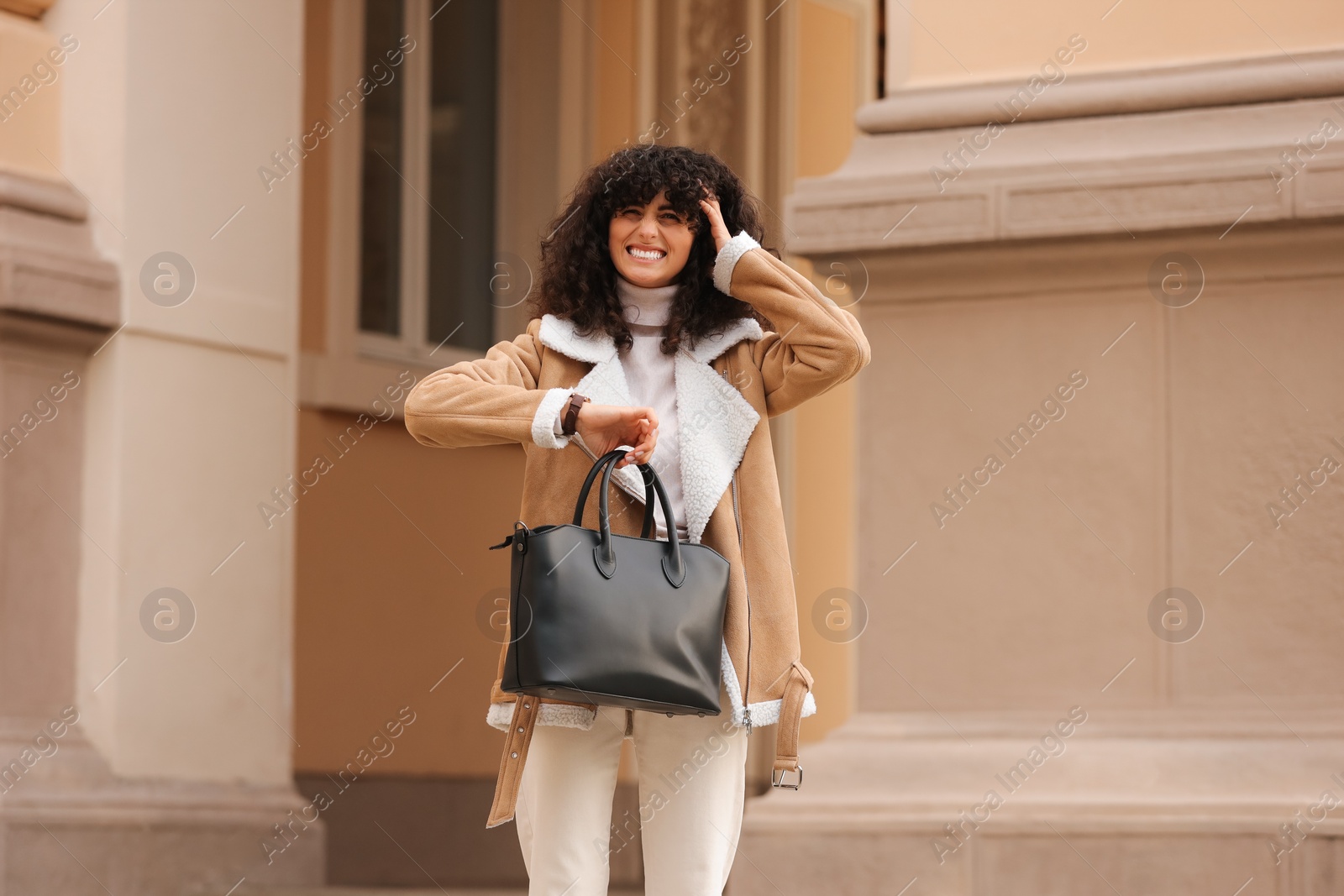 Photo of Being late. Emotional woman with bag near building outdoors