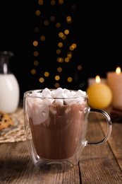 Photo of Glass cup of cocoa with marshmallows on wooden table