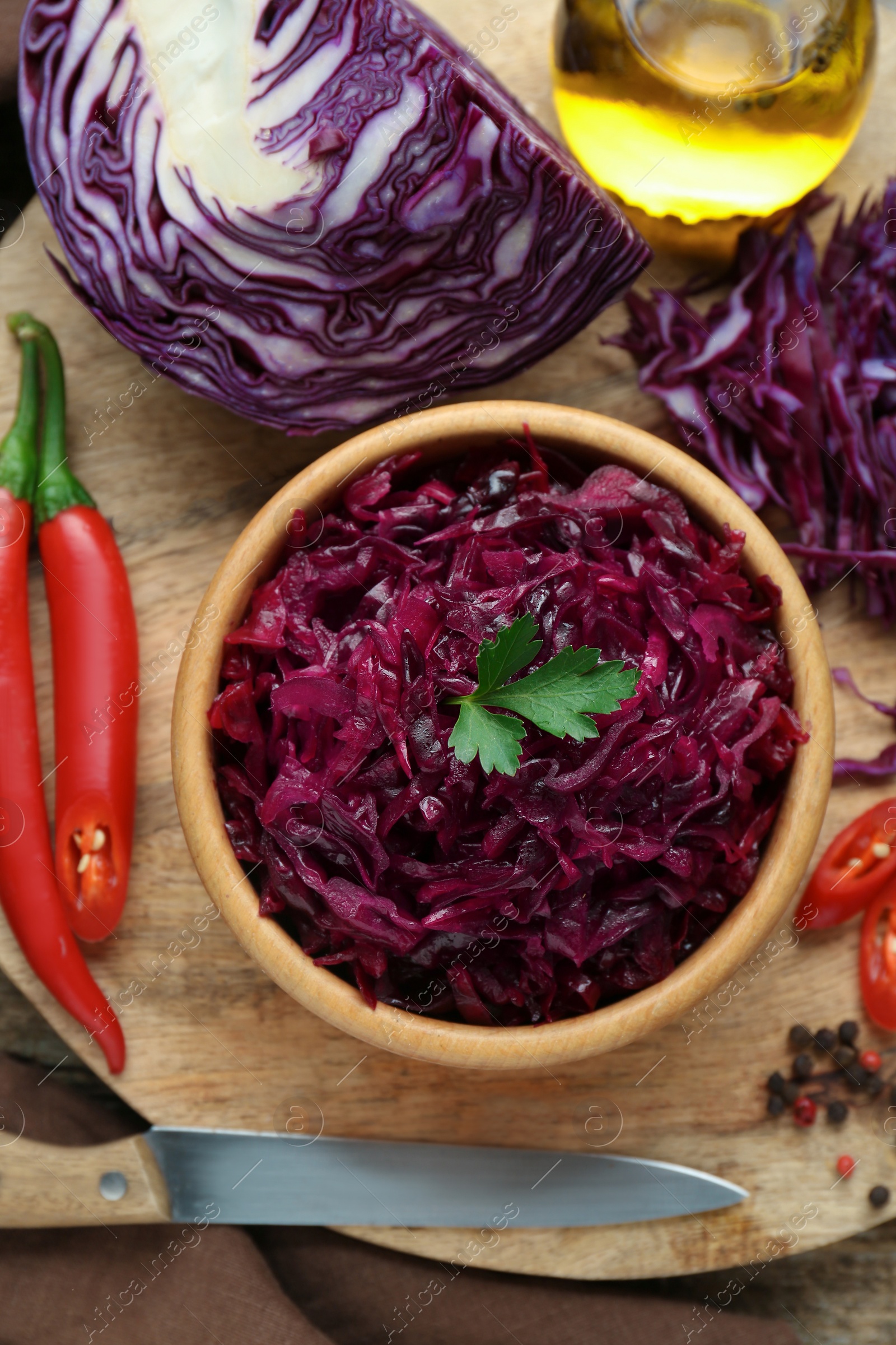 Photo of Tasty red cabbage sauerkraut and ingredients on wooden table, flat lay