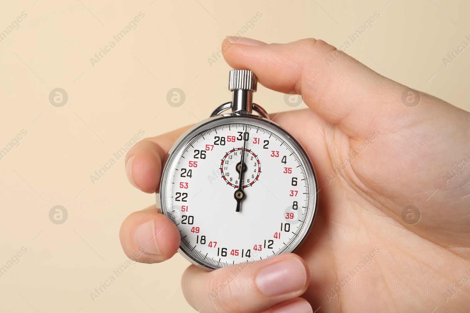 Photo of Woman holding vintage timer on beige background, closeup