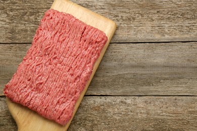 Photo of Board with raw fresh minced meat on wooden table, top view. Space for text