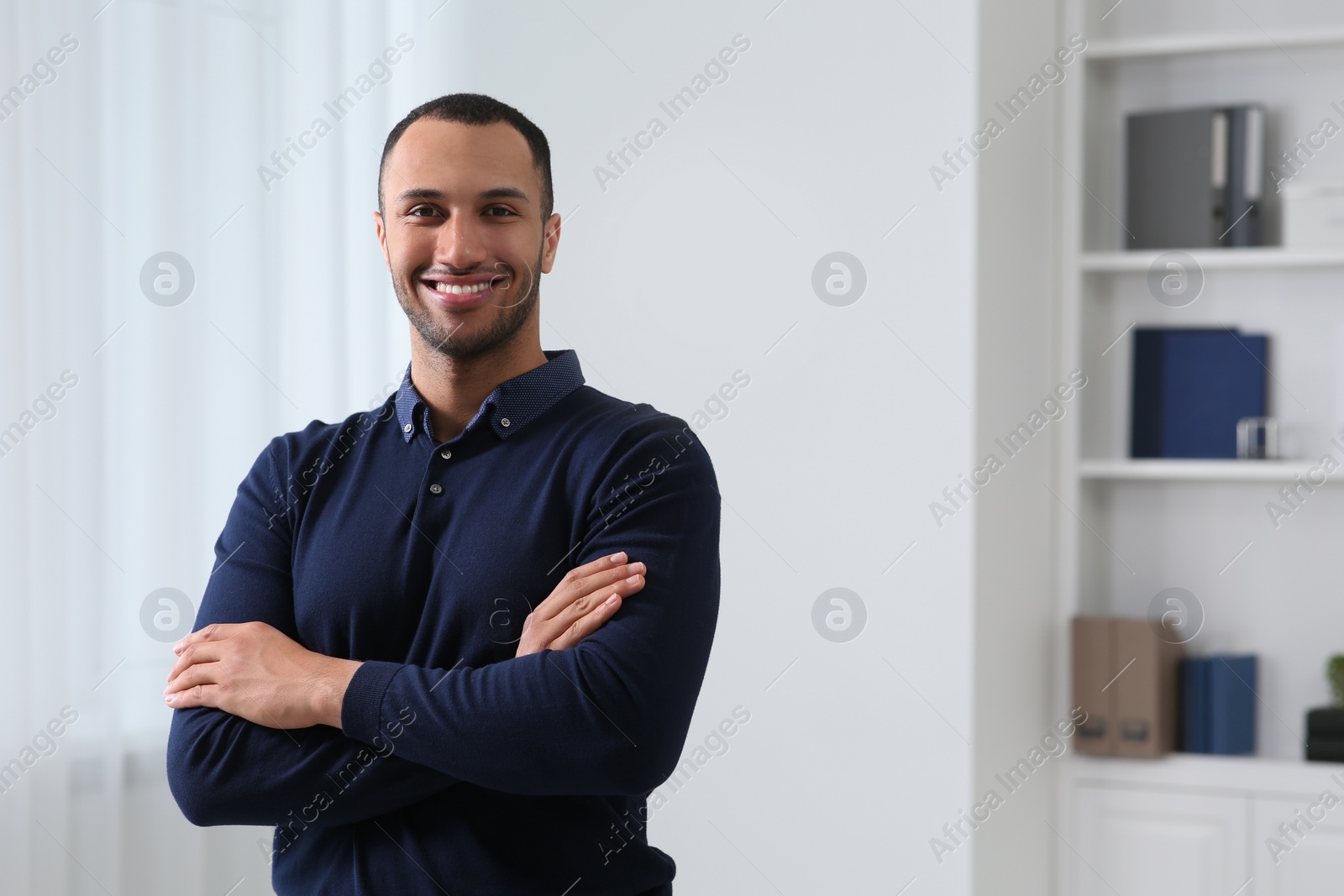 Photo of Smiling young businessman in office. Space for text