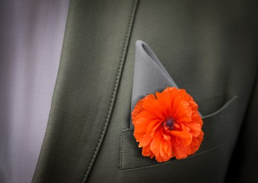 Man with with red poppy flower in suit pocket, closeup view. Remembrance symbol