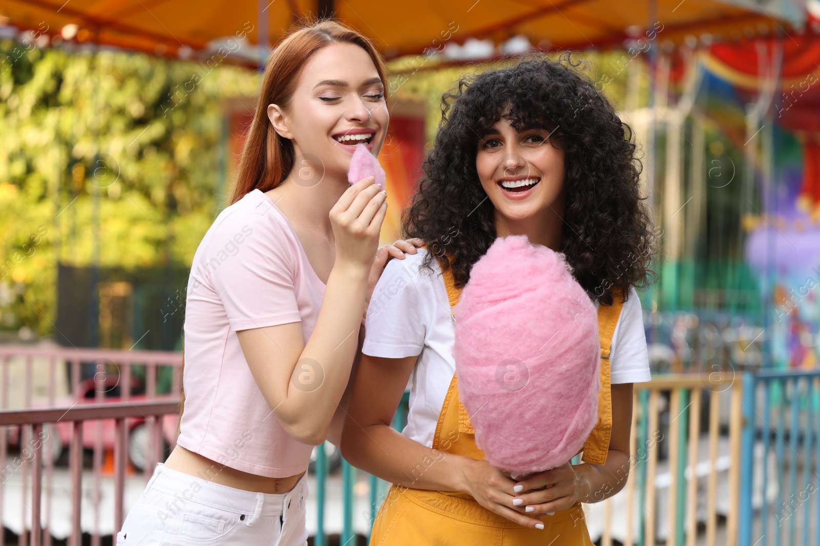 Photo of Happy friends with cotton candy at funfair