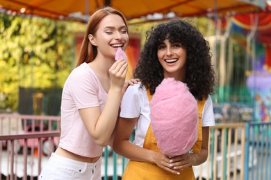 Photo of Happy friends with cotton candy at funfair