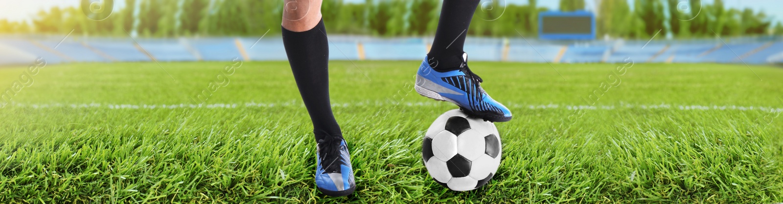 Image of Football player with ball on green grass at stadium, closeup. Banner design