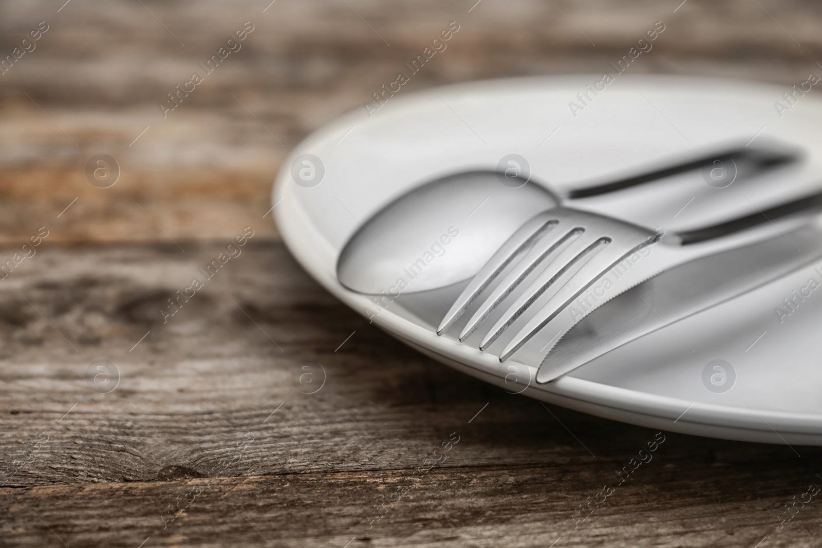 Photo of Empty dishware and cutlery on wooden table, close up view. Table setting