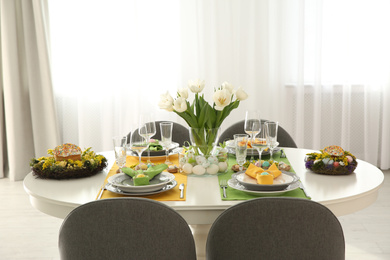 Photo of Festive Easter table setting with beautiful white tulips and eggs indoors