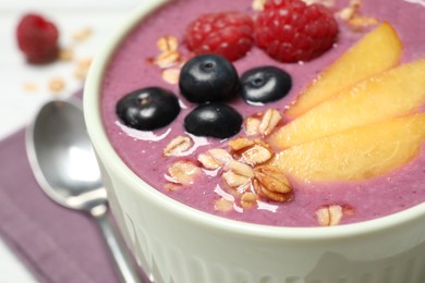 Photo of Delicious acai smoothie with peach slices and oatmeal in bowl, closeup