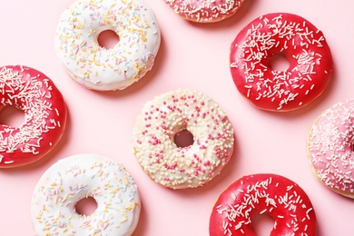 Photo of Delicious glazed doughnuts on color background, top view