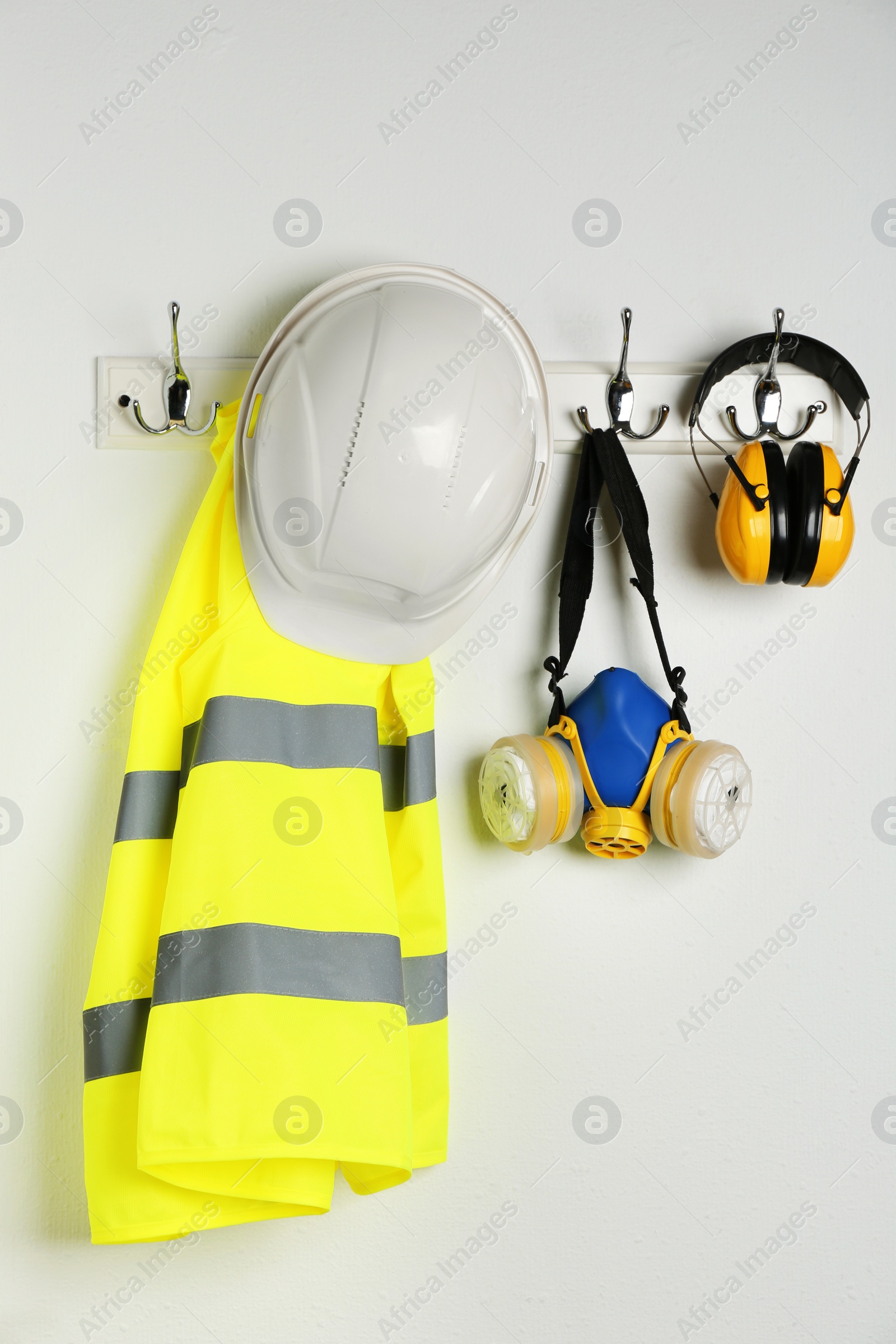 Photo of Different safety equipment hanging on white wall