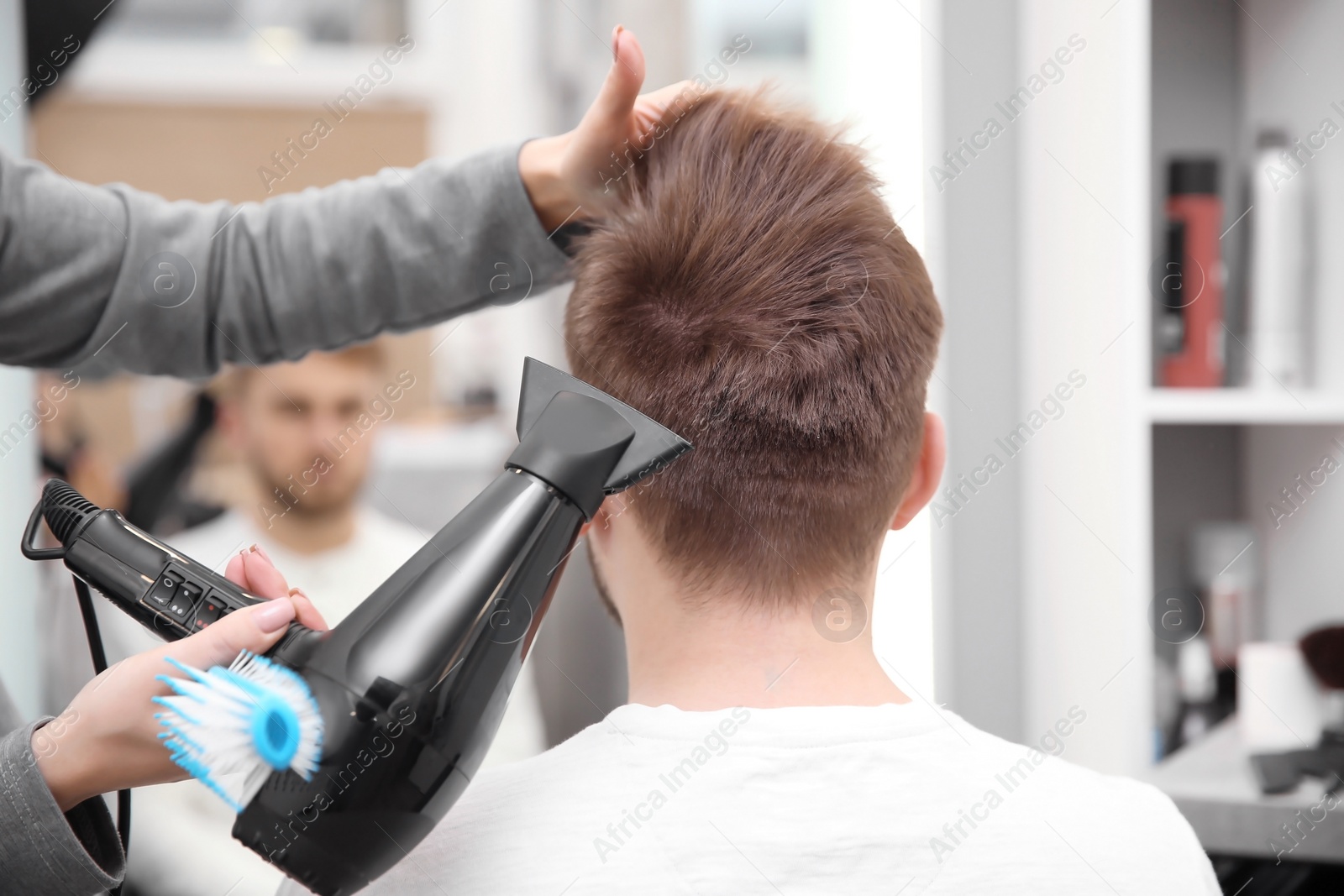 Photo of Professional female hairdresser working with client in salon