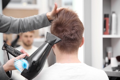 Professional female hairdresser working with client in salon