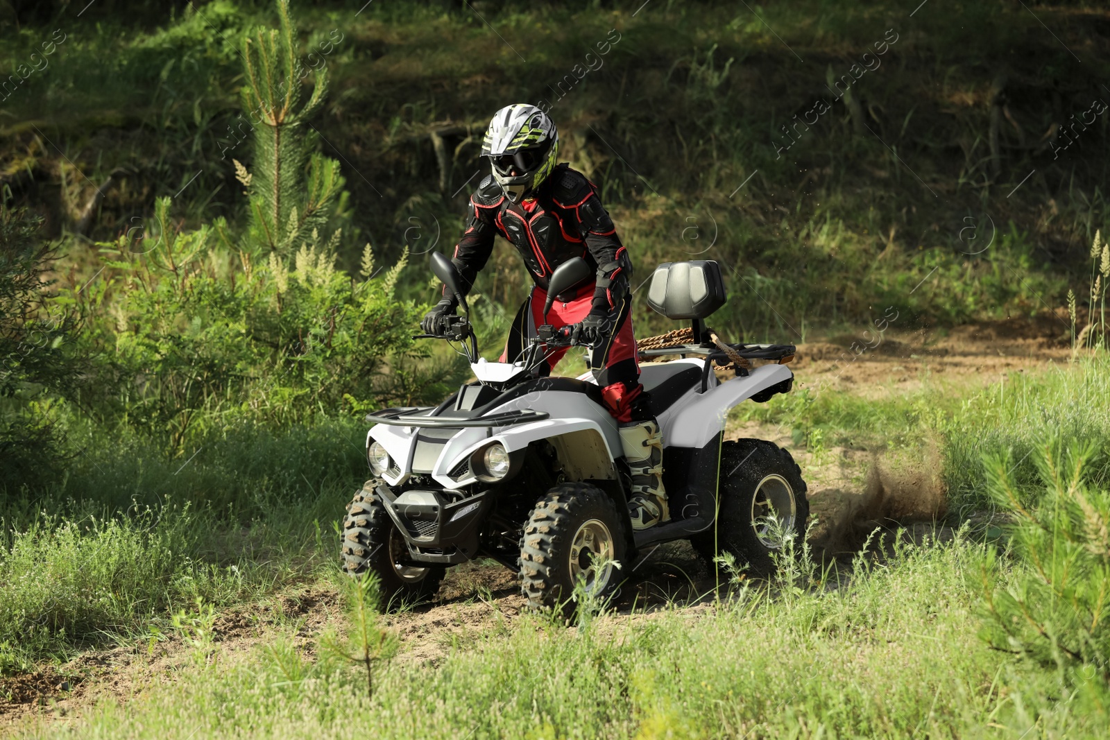 Photo of Man driving modern quad bike on sandy road. Extreme sport