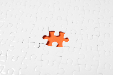Photo of Blank white puzzle with missing piece on orange background