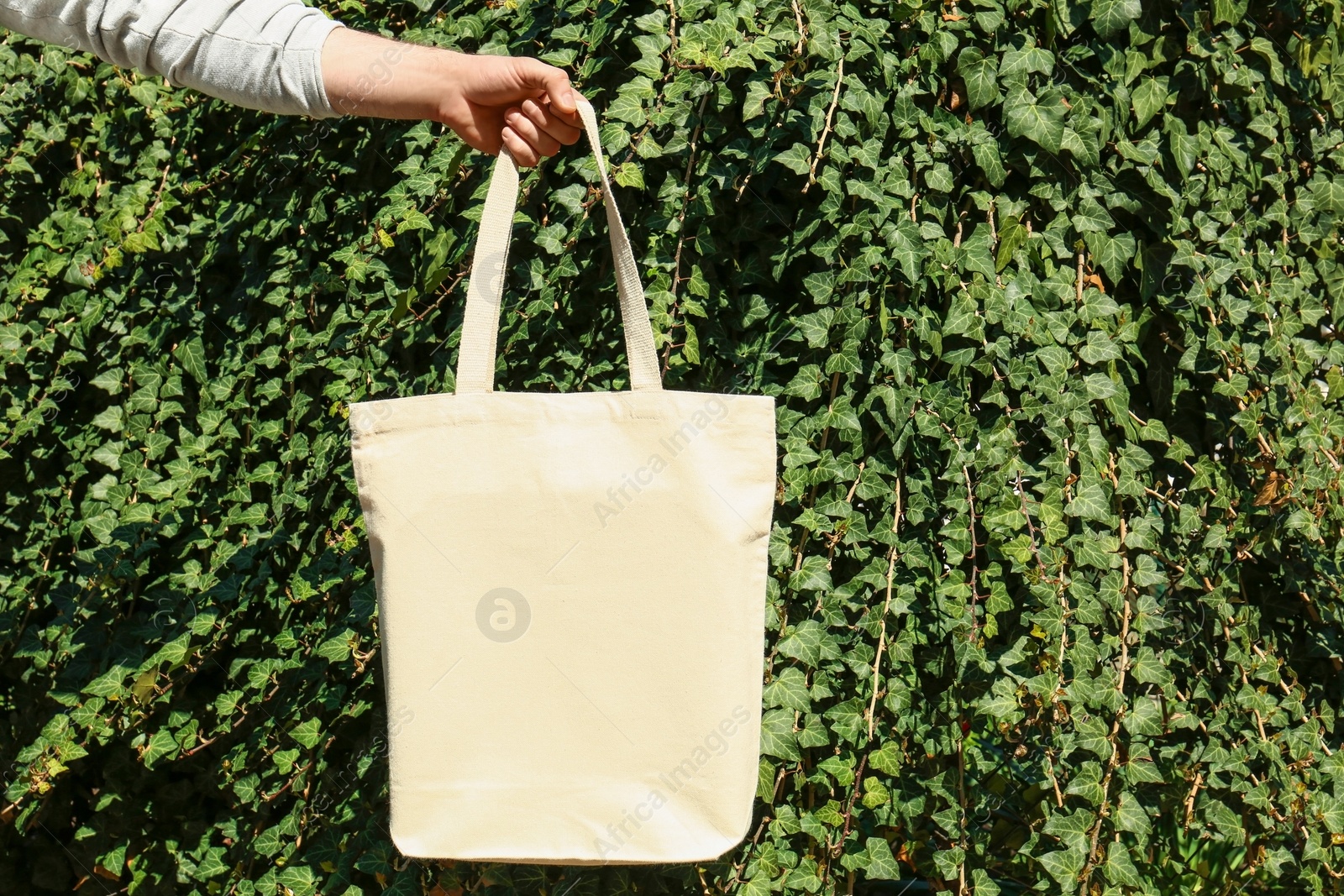 Photo of Woman holding eco bag outdoors, closeup. Mockup for design