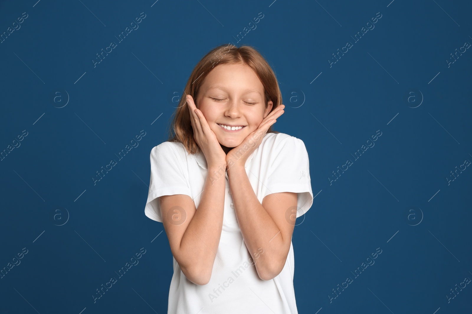 Photo of Portrait of emotional preteen girl on blue background