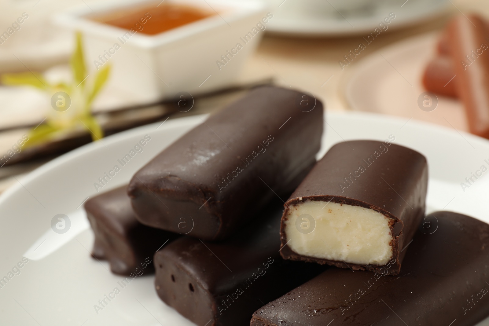 Photo of Glazed vanilla curd cheese bars served on table, closeup